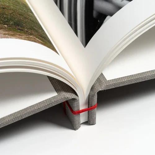 Dettaglio del dorso in tela con legatura giapponese a mano e filo rosso a contrasto - Olimpia Fine Art